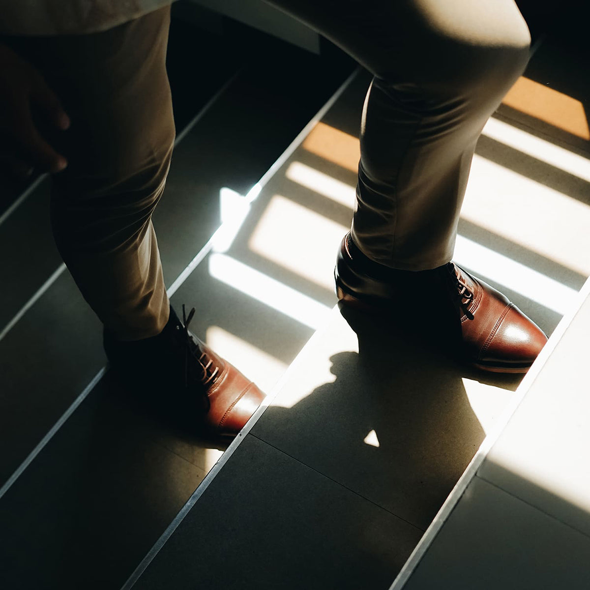 A person climbing stairs wearing a genuine leather captoe for his wedding